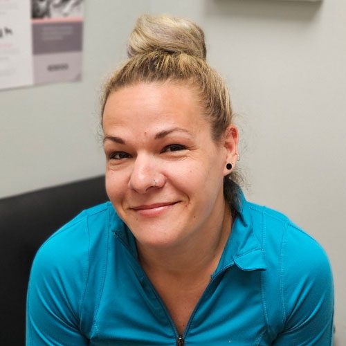 close up of smiling woman with her hair up in a bun