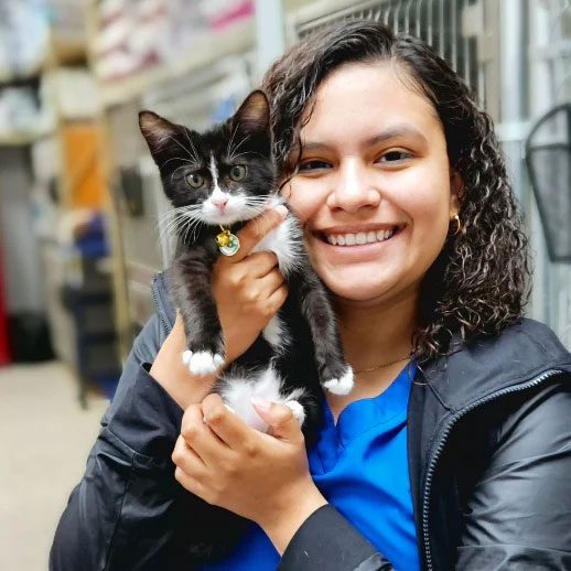 smiling young woman holding a kitten